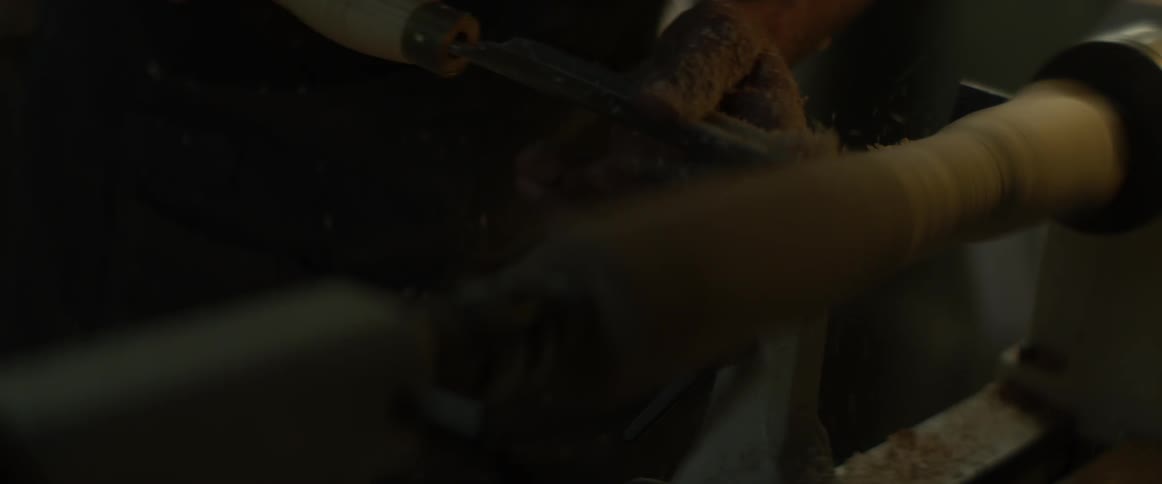 Someone is using a chisel and a woodturner to carve a piece of wood