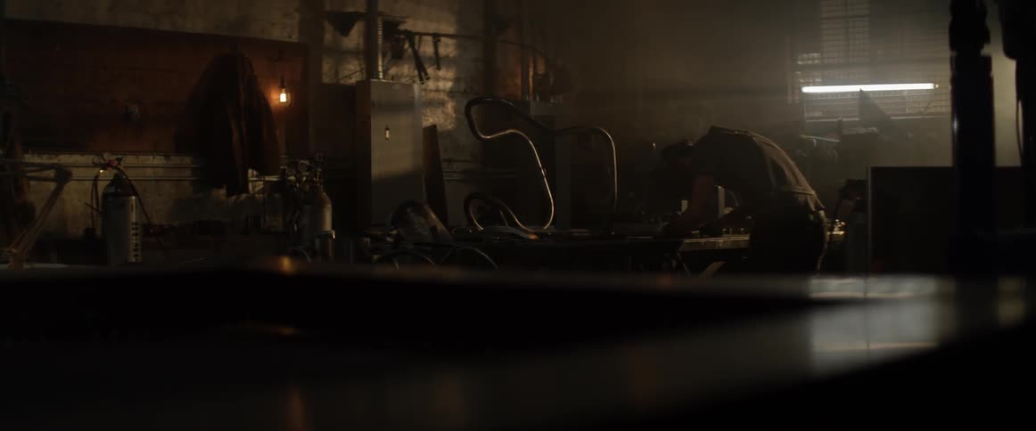A man works in a workshop with a welding torch