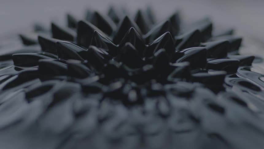 Black liquid ripples up into a spiked pattern