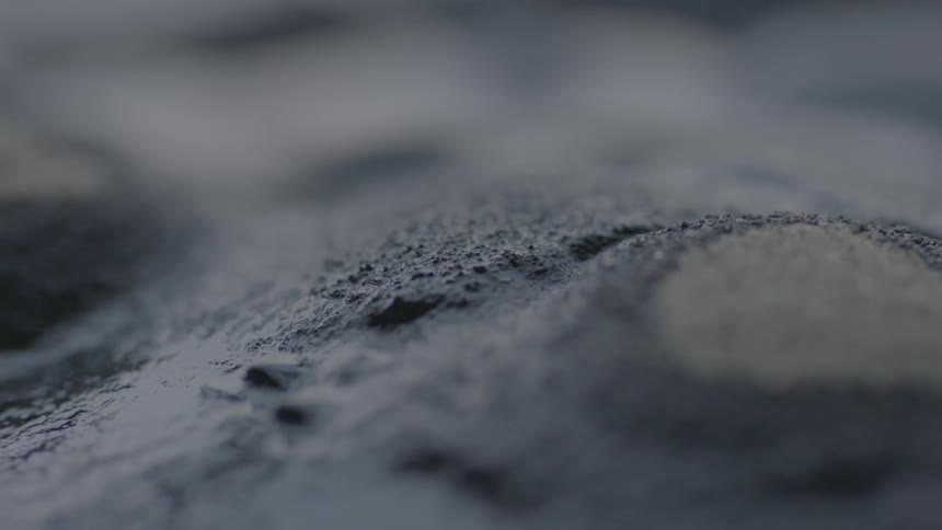 A liquified substance oozes and forms cones in abstract
