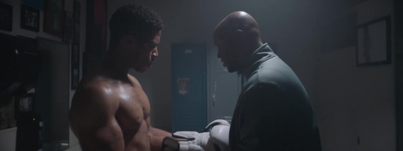 A man helps wrap the boxing gloves on a fighter