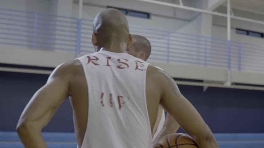 Two men talking on a basketball court