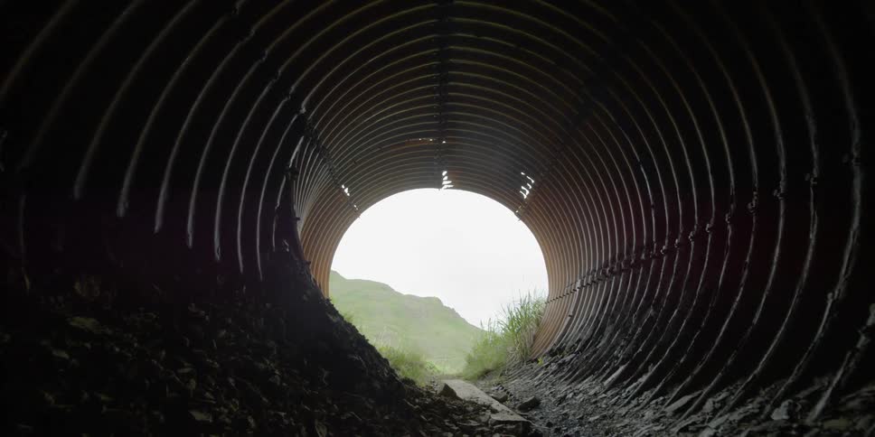 The dark tunnel leads to a foggy area ahead