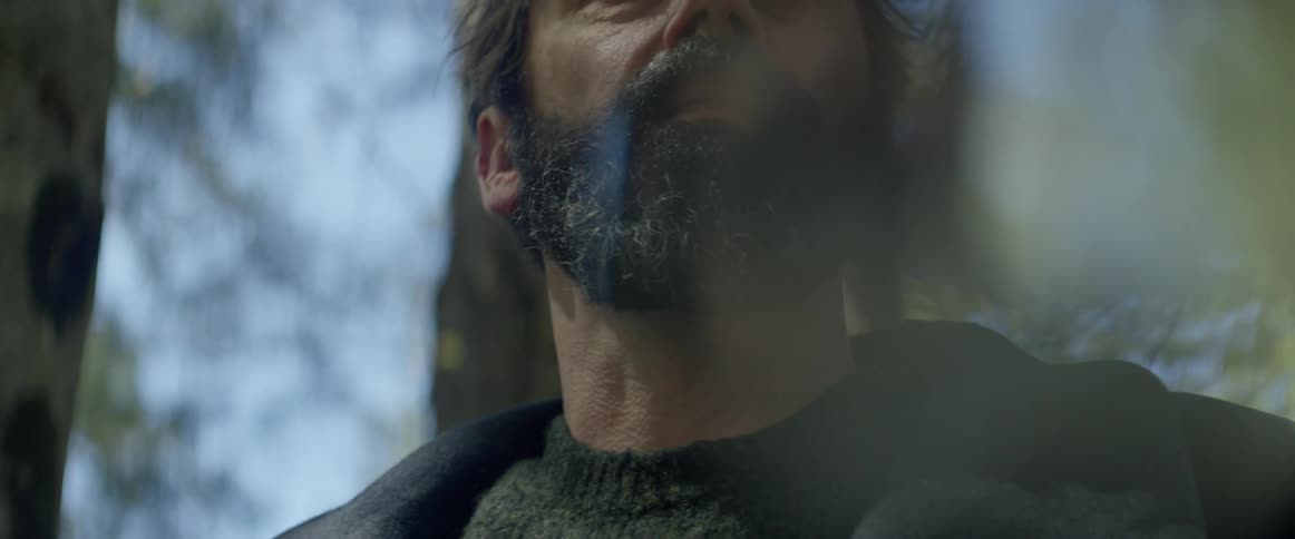 A man stands outside and looks upward