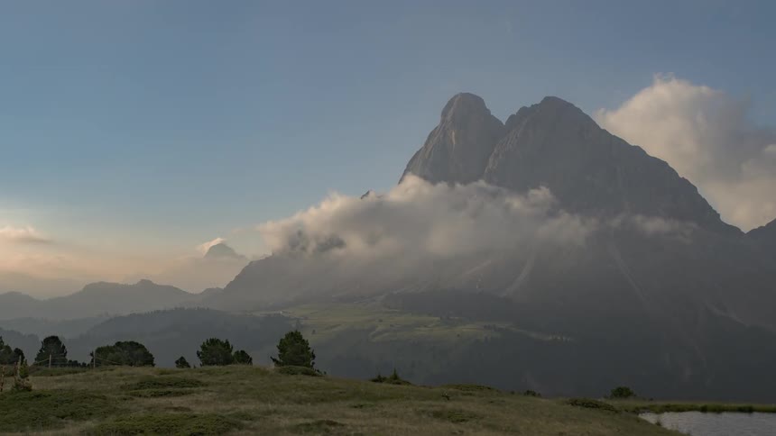 Clouds move over rocky peaks and fields