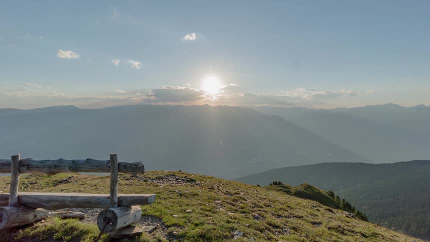 A bench at the top of a mountain overlooks a valley