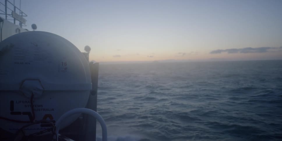A boat travels on the water at sunrise