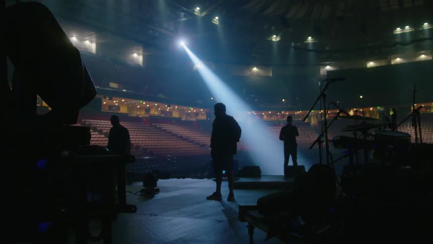 Musicians prepare on the dark stage