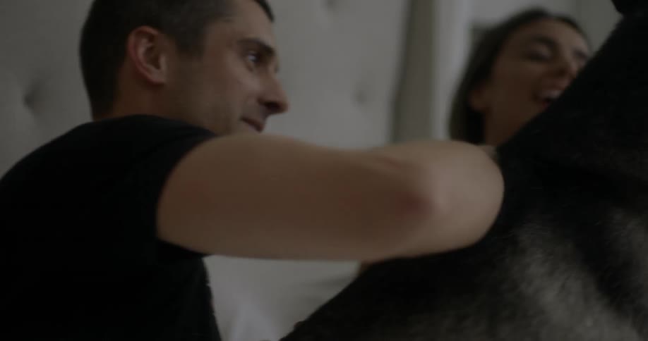 A husky dog is in the bed of a man and woman