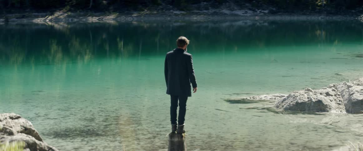 A man stands on a rock in a lake