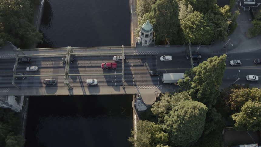 Rowers glide along the Montlake Cut as morning traffic flows above