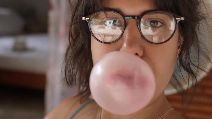 A woman playfully blows a bubble