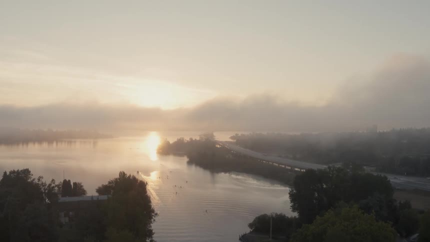 Flying past rowers on Union Bay as fog rises from Lake Washington at sunrise