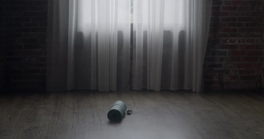 Yoga mat on wooden floor in empty room