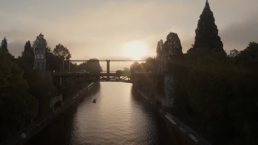 Sunrise reveal of the Montlake Bridge as a tugboat travels along below