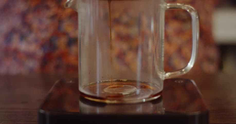 Liquid is being poured into a pitcher very slowly