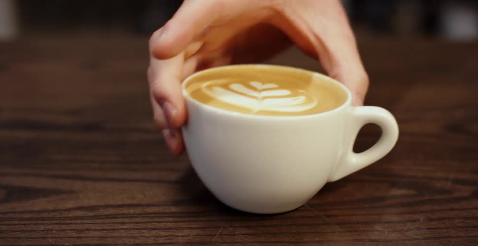 A hand picks up a latte