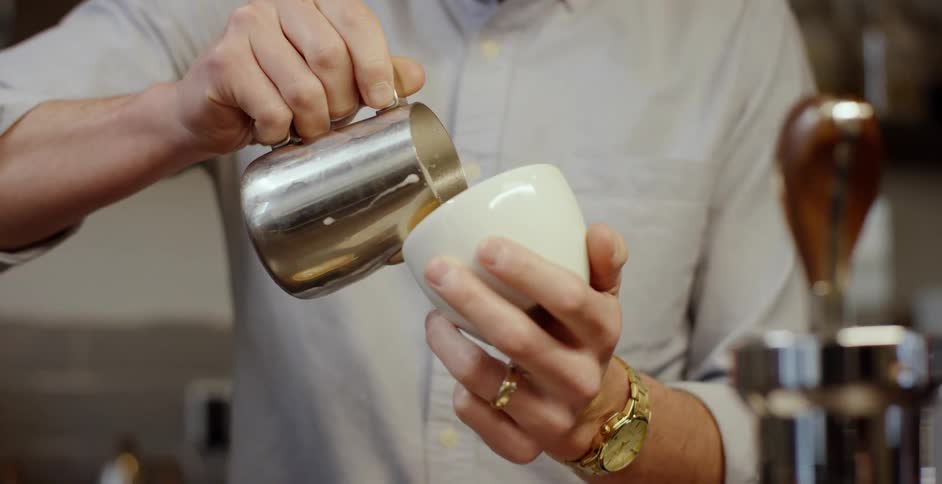 A man pours cream into a small cup