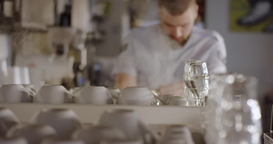 A man sits behind a counter in a restaurant