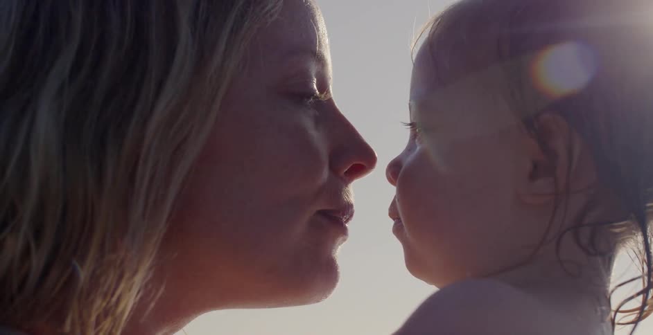 A mother rubs noses with her baby