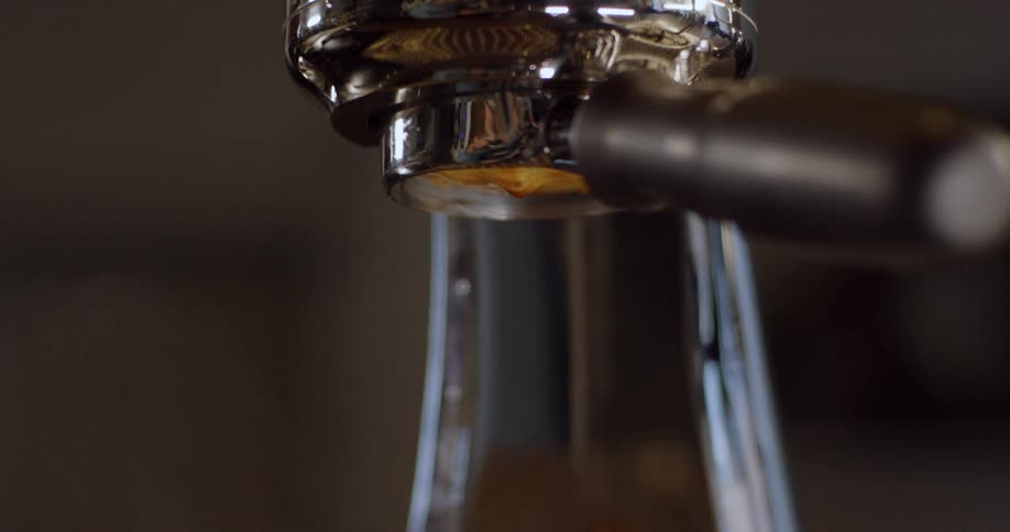 Espresso drips from a machine