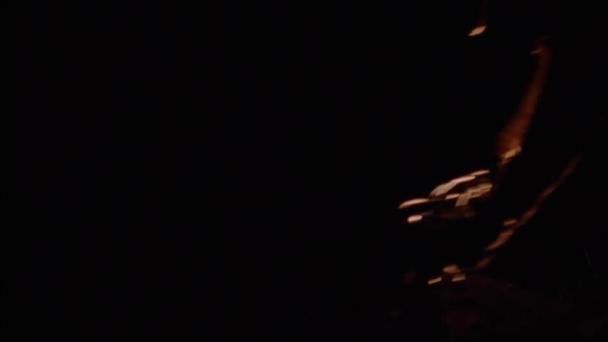 People race on dirt bikes in the dark