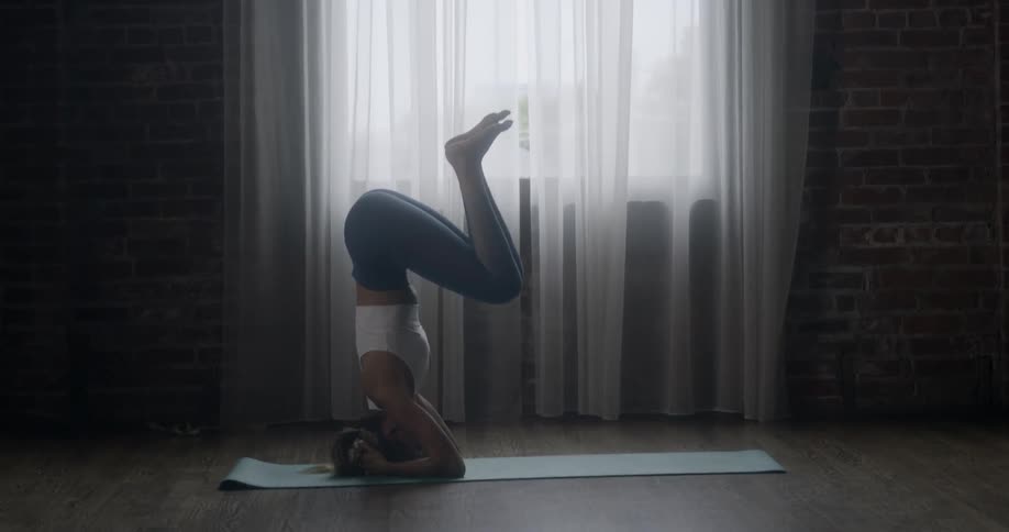 A woman is doing yoga in her living room