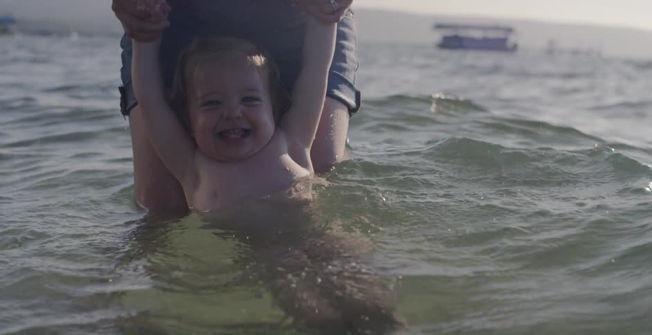A parent and child play in the water