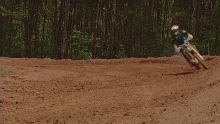 Person rides a dirt bike on a rural track