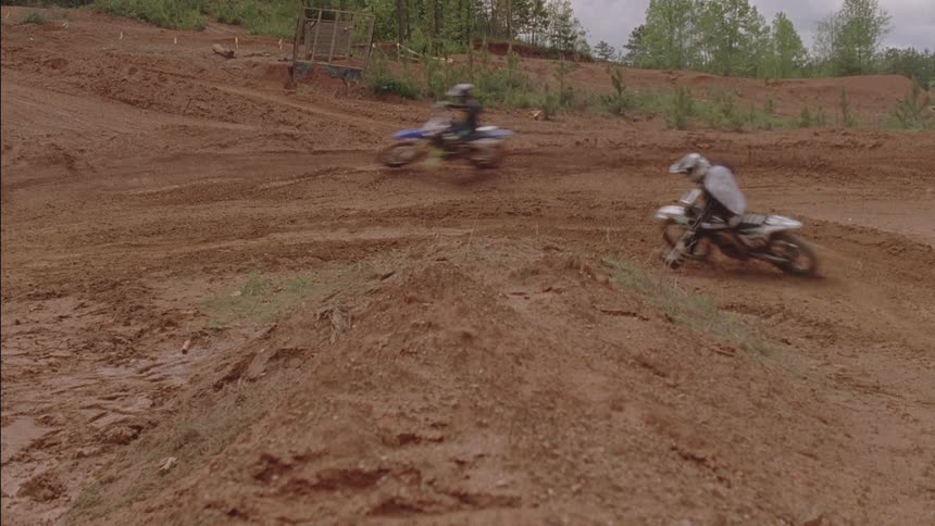 Motocross riders traverse a dirt course
