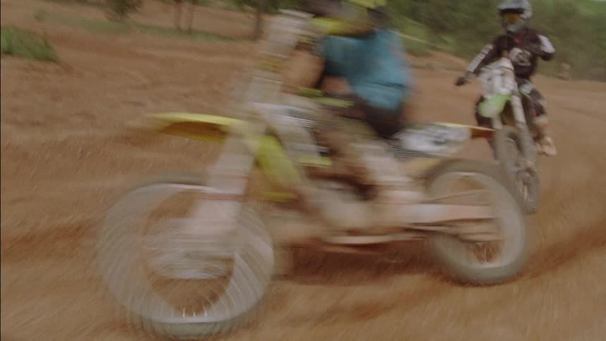 Motocross riders traverse a dirt course
