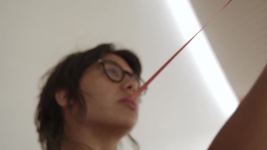 A woman stretches a piece of gum