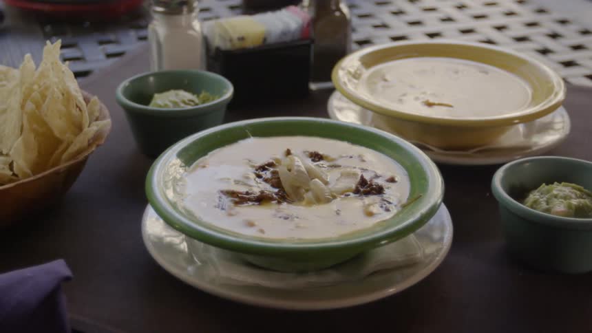 Bowls of suit sit on a table with tortilla chips