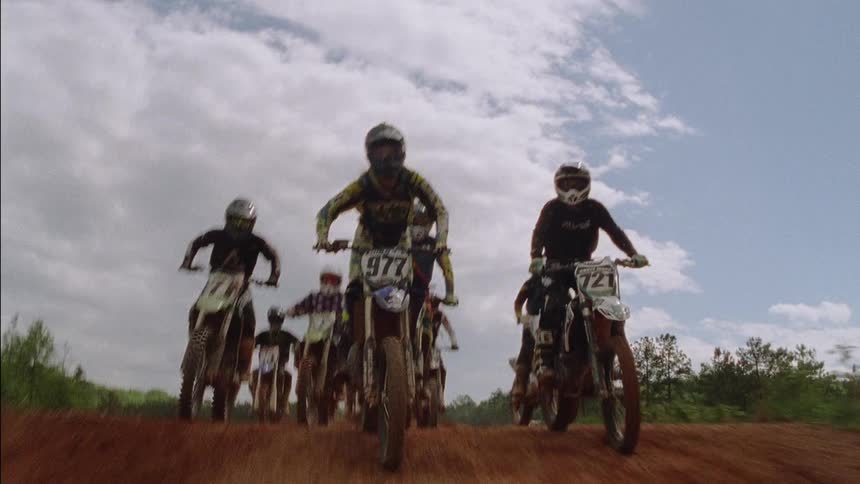 Motocross riders traverse a dirt course