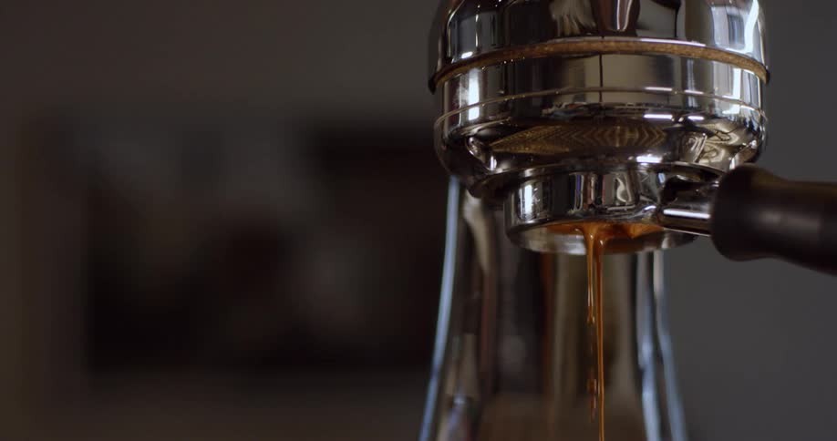 Espresso drips from a machine