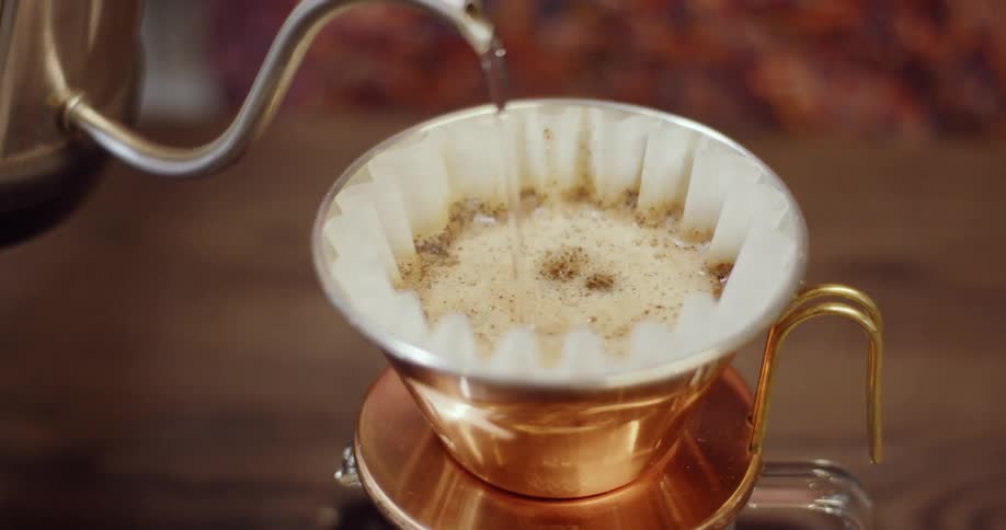 Water is being poured into a drip coffee brewer