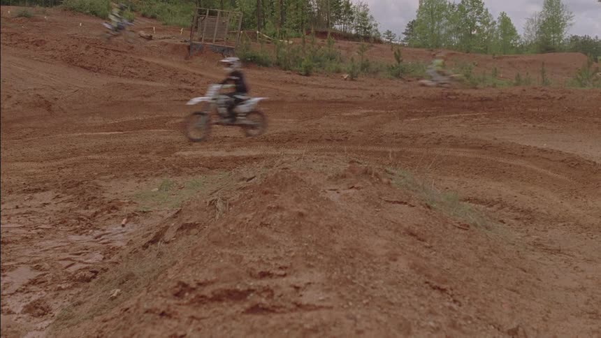 People ride dirt bikes on a course