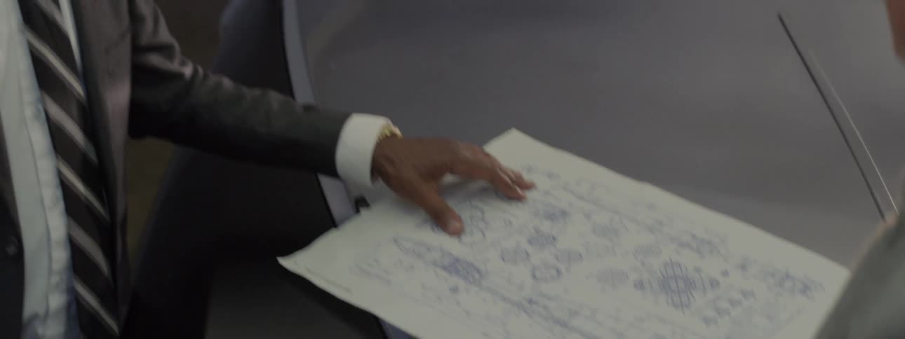 A man is talking with someone looking at blueprints