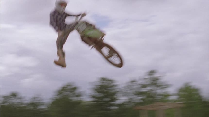 Dirt bike riders are taking their bikes off of a big jump
