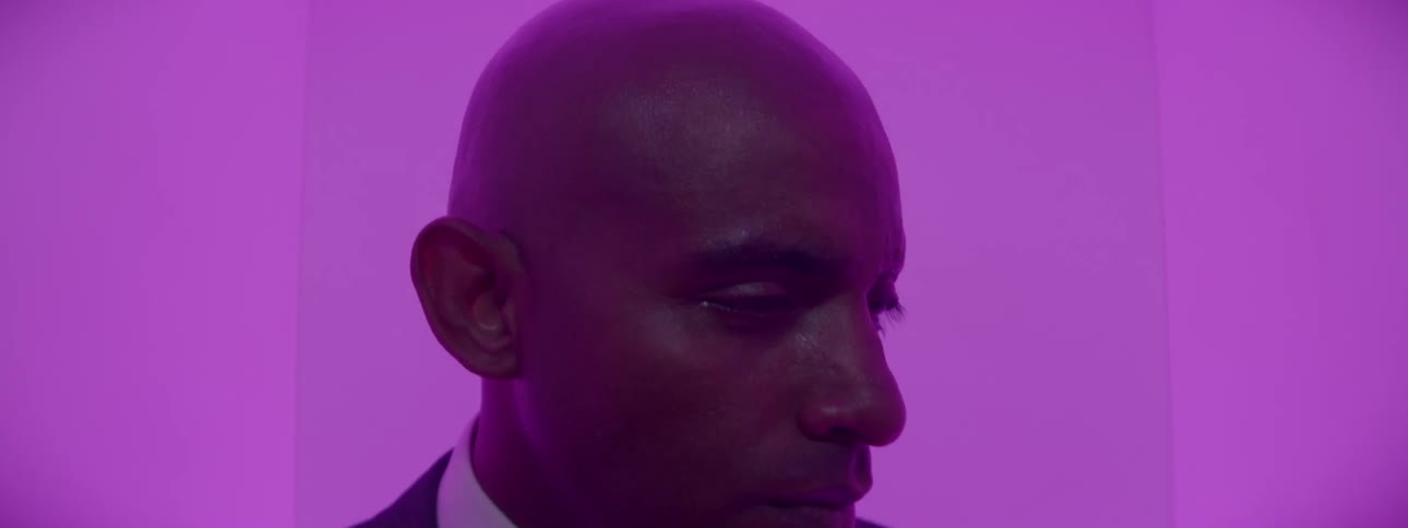 A man looks to the side in a dark room