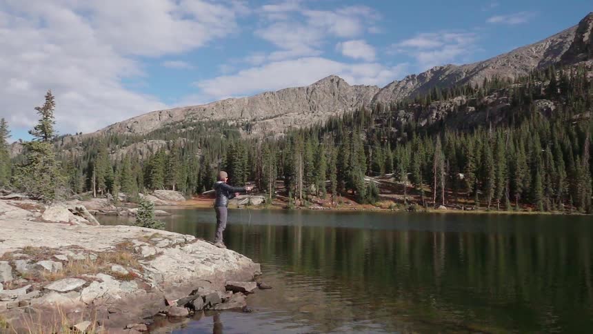 A man fishes beside a river