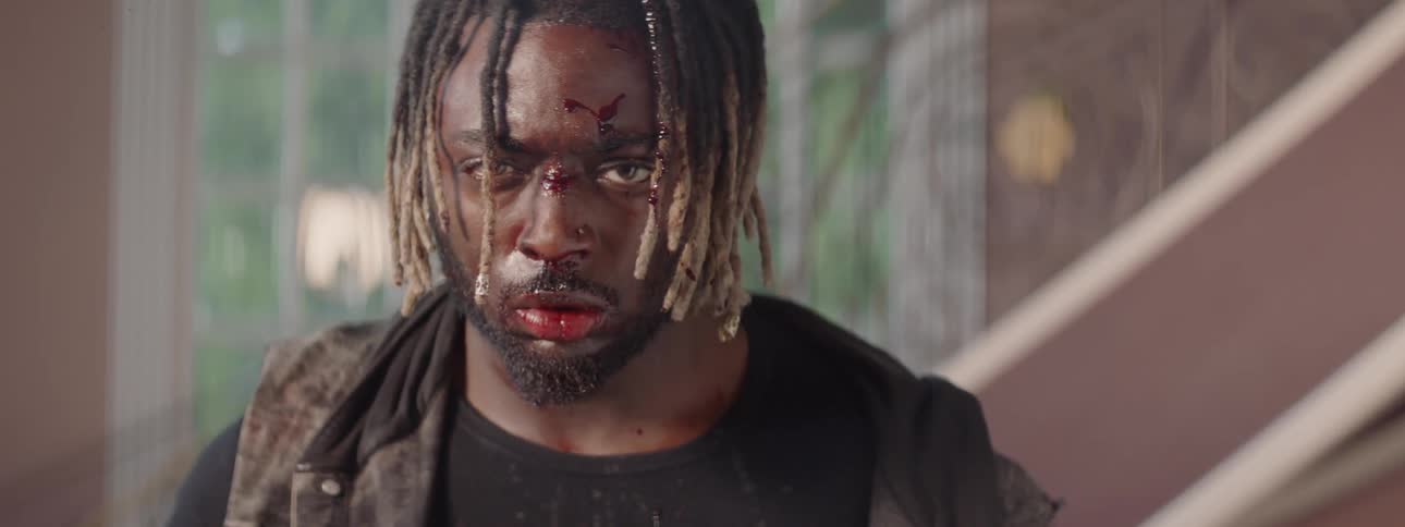 A man slashes at someone and blood splatters onto his face