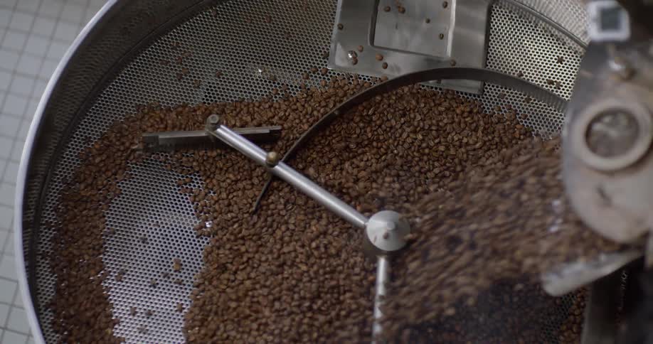 Coffee beans are added to a roaster