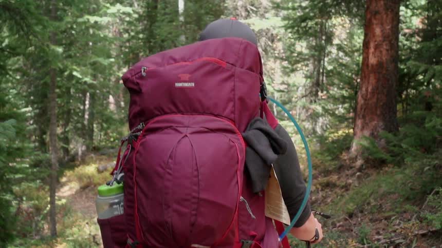 A hiker is traveling through the woods
