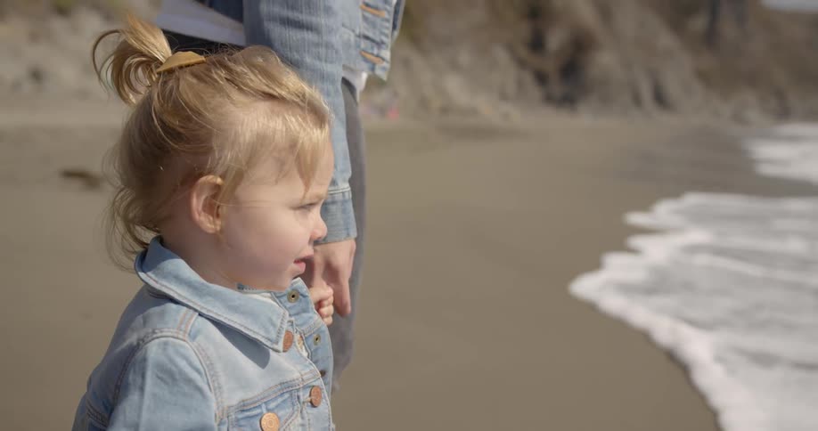 A mother and daughter standing on the beach