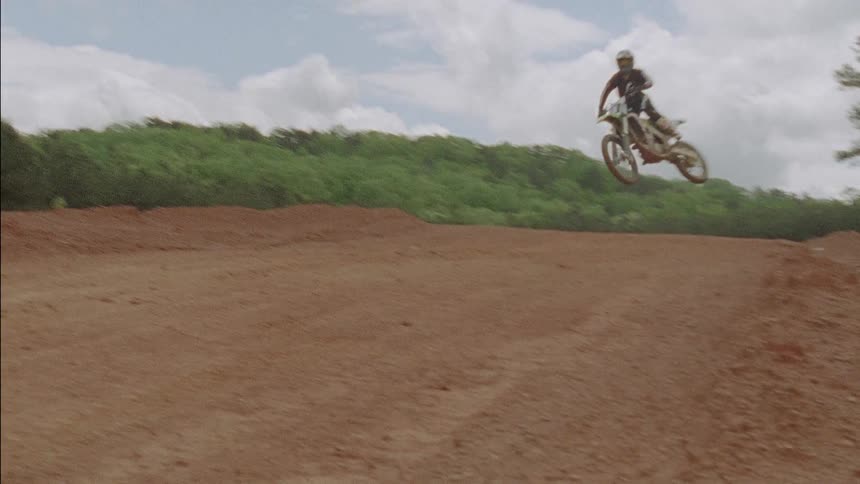 Man riding a dirt bike along a track