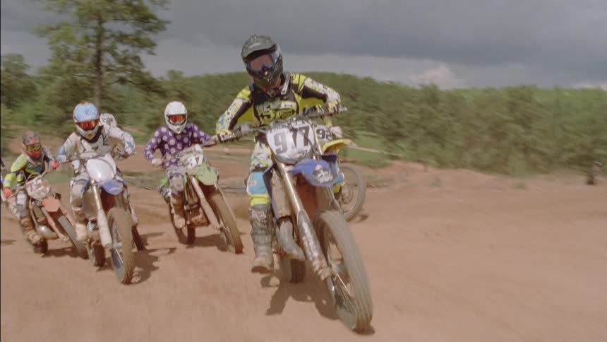 Riders are racing dirt bikes around a track