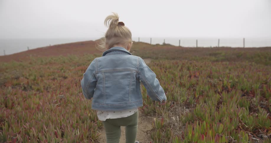 A child walks down the small trail on a windy day