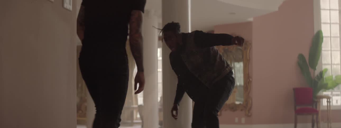 A man kicks the gun out of another man's hands and fights him