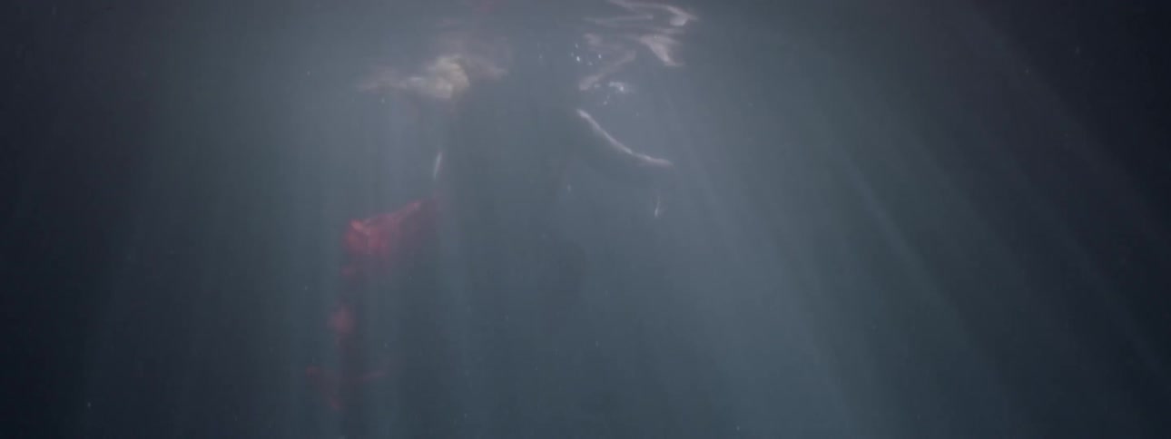 A woman in a red dress treads water